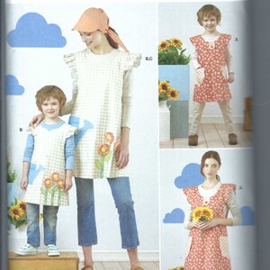 May include: Simplicity sewing pattern R11756 for an easy-to-sew apron with ruffled shoulders and pockets. The pattern features designs with floral and watering can appliqués, shown in gingham and floral fabrics for both adults and children.