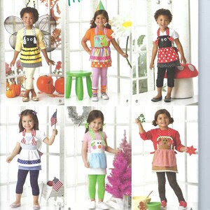 May include: A sewing pattern for making children's aprons. The pattern includes five different apron designs: a bee, a clown, a snowman, a reindeer, and a ladybug. The pattern is from Simplicity and is size A, S, M, L. The pattern number is 1954.