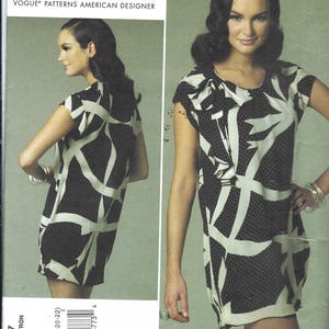 May include: Vogue Patterns American Designer Anna Sui sewing pattern V1217. The pattern features a black and white patterned dress with a unique design. The dress has short sleeves and a round neckline. The pattern includes sizes 14-16-18-20-22.