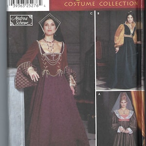 Könnte beinhalten: Simplicity Renaissance Kostümkollektion Schnittmuster. Das Bild zeigt eine Frau in einem bordeauxfarbenen Kleid mit goldenen Akzenten und passendem Kopfschmuck. Das Schnittmuster enthält die Größen 6, 8, 10 und 12. Das Schnittmuster wurde von Andrea Schewe entworfen.