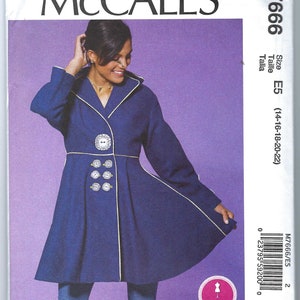 Puede incluir: Un abrigo azul con ribete blanco y botones decorativos. El abrigo tiene cuello y falda acampanada. La modelo lleva pantalones vaqueros azules. Patrón McCall's M7666, talla E5 (14-16-18-20-22).