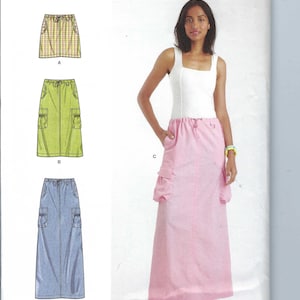 Peut inclure: Patron de couture Simplicity R12025 avec trois modèles de jupes : une mini-jupe à carreaux, une jupe cargo verte et une jupe longue en jean bleu. Le mannequin porte une jupe cargo rose avec un haut blanc.