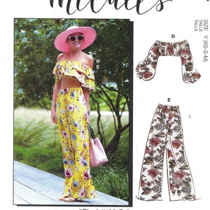 May include: A sewing pattern for a women's outfit with a floral print. The pattern includes a crop top, wide-leg trousers, and a hat. The pattern is called "#CharlotteMcCalls".