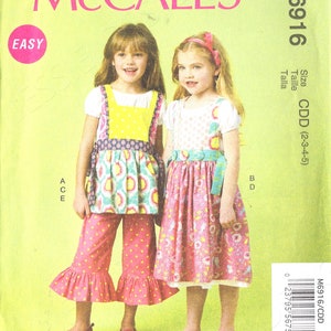 Pode incluir: Um padrão de costura para dois vestidos de menina. O padrão chama-se McCall's M6916 e é para os tamanhos 2-3-4-5. O padrão é rotulado como fácil. As meninas na foto estão a usar os vestidos, um com um estampado floral rosa e branco e o outro com um estampado amarelo, azul e branco.