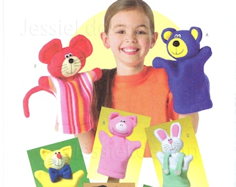 Puede incluir: Un patrón Butterick B4209 para hacer marionetas de mano de animales de peluche. La imagen muestra a un niño con varias marionetas terminadas: un ratón, un oso, un cerdo, un gato, un perro, un conejo y un mono. Las marionetas son coloridas.