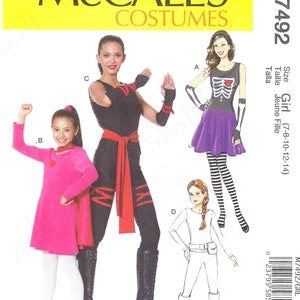 Puede incluir: Patrón de costura para tres disfraces de niña. El primer disfraz es un traje de ninja negro con una faja roja. El segundo disfraz es un disfraz de esqueleto negro y morado. El tercer disfraz es un mono blanco con un cinturón. El patrón es para las tallas 7-8, 10-12 y 14. McCall's Costumes M7492/GRL.