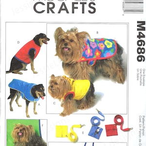 Puede incluir: Un sobre de patrón de McCall's Crafts con diseños de ropa para perros. La imagen muestra varios abrigos y accesorios para perros en diferentes colores, incluyendo rojo, azul y amarillo. El patrón incluye diseños de cama para perros y correa.