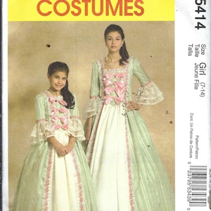 May include: McCall's Costumes pattern featuring two girls in elegant, light green and white dresses. The dresses have pink bows, lace trim, and bell sleeves. The pattern is labeled M5414, with size information for girls aged 7-14.