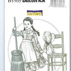May include: A Butterick sewing pattern envelope, B4569, featuring a young girl in a floral dress, apron, and bonnet. The illustration includes a churn and a wooden chair. The text "MAKING HISTORY" is also visible.