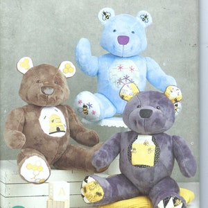 May include: A Simplicity sewing pattern for making three plush teddy bears. The bears are brown, blue, and purple. Each bear has a beehive design on its chest and bee accents on its ears. The pattern number is R11696. The pattern is for one size.