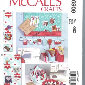 May include: McCall's Crafts sewing pattern M6909. The image shows various sewing projects, including a wall organizer, magazine holders, a sewing basket, and a pincushion. The projects feature floral and polka dot patterns.