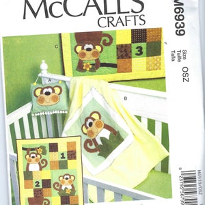 May include: A sewing pattern for a baby quilt featuring a monkey theme. The quilt is made up of squares with various colours and patterns, including green, yellow, brown, and white. The pattern includes instructions for making a cot quilt, a wall hanging, and a burp cloth. The pattern is called "Sew Sweet Chic" by Susan Cousineau.