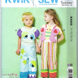May include: A sewing pattern for toddlers featuring two different designs. The first design is a blue and green monster jumpsuit with a large eye on the front. The second design is a pink and yellow butterfly jumpsuit with a red heart on each wing. The pattern is called "Kwik Sew" and the number is K4205.