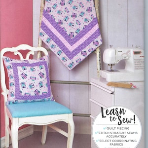 May include: A sewing pattern for a quilt and pillow featuring a cute owl design. The pattern is from Simplicity and is labeled S9410. The pattern includes instructions for quilting, stitching straight seams, selecting coordinating fabrics, and applying batting.
