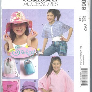 Könnte beinhalten: Ein Schnittmuster für verschiedene Accessoires, darunter ein Hut, ein Poncho, eine Tasche und eine Handtasche. Das Schnittmuster heißt "Sassy Girl" und stammt von McCall's Fashion Accessories. Die Schnittmuster-Nummer ist M5069.