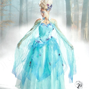 Puede incluir: El patrón Simplicity 8629 presenta un vestido de fantasía con un diseño fluido en azul claro. El vestido tiene una falda en capas y mangas transparentes tipo capa. El patrón incluye tallas Euro 32-40. El logotipo de Simplicity es visible.