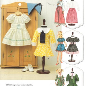 May include: Simplicity doll clothes pattern 8575. The pattern includes several doll dress designs, including a white dress with blue accents, a yellow dress with a white collar, and a green dress with a white collar. The pattern is for dolls 18 inches (45.5 cm) tall.