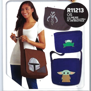 May include: A sewing pattern for messenger bags and laptop sleeves featuring characters from the Star Wars: The Mandalorian TV series. The pattern includes a blue bag with a green frog, a blue bag with a character from the show, a brown bag with a character from the show, and a gray bag with a symbol from the show. The pattern is labeled "R11213 OS" and includes the text "starwars.com &copy; & TM Lucasfilm Ltd. Disney+"