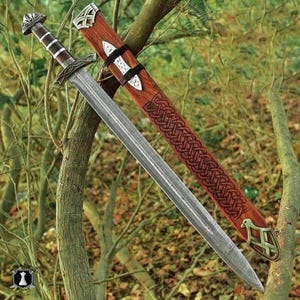 May include: A Viking-style sword with a silver blade and a brown handle. The sword is displayed with its wooden sheath, which features intricate Celtic knotwork and metal accents. The handle has a detailed design.