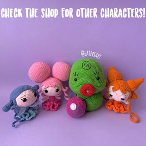 May include: Four handmade crochet dolls featuring distinct designs: a blue figure, a pink character with large round hair buns, a green rounded creature with a red mouth, and an orange figure with glasses. Text reads: CHECK THE SHOP FOR OTHER CHARACTERS!