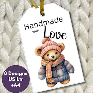 May include: A white tag with the text "Handmade with Love" and a watercolor illustration of a teddy bear wearing a pink hat, scarf, and blue coat. The tag also includes a purple circle with the text "8 Designs US Ltr +A4".