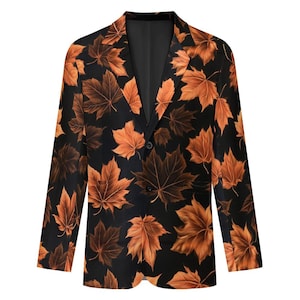 May include: A black blazer featuring a repeating pattern of orange and brown maple leaves. The garment has a notched lapel, long sleeves, and a two-button front closure. The interior lining is solid black, visible at the collar and lapels.