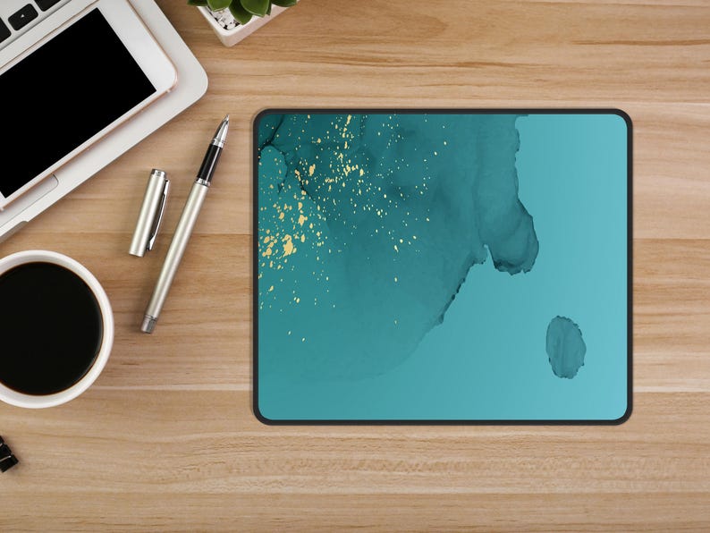 May include: A teal blue mouse pad with a white and gold abstract design. The design features a large, flowing shape with gold flecks throughout.