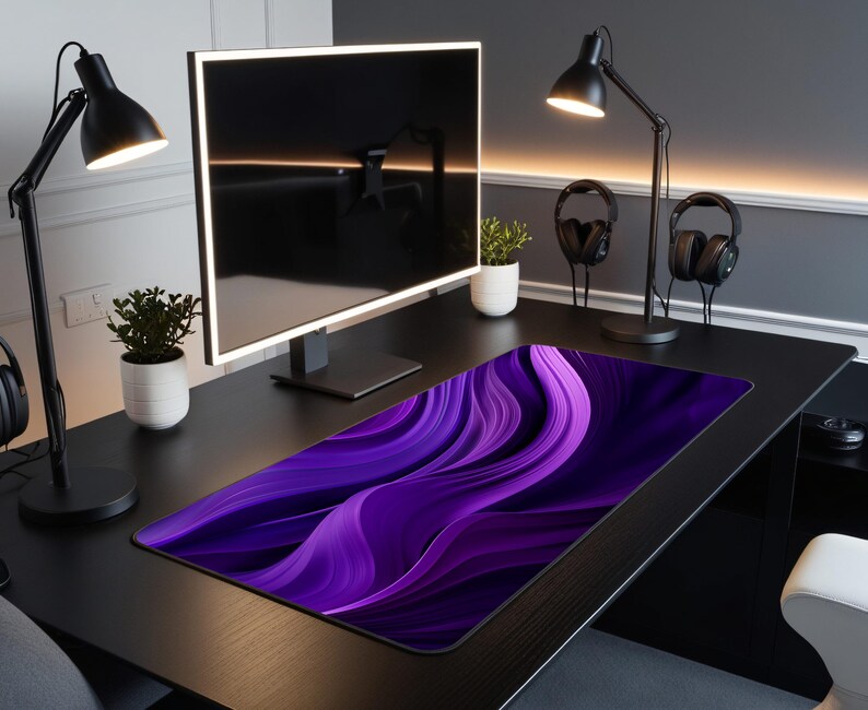 May include: A purple and black abstract design mousepad with a wavy pattern. The mousepad is on a black desk with a computer monitor, two lamps, and two headphones.