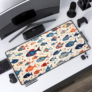 Peut inclure: Un tapis de souris blanc avec un motif coloré de poissons bleus, orange et rouges. Les poissons sont disposés de manière aléatoire et sont entourés d'algues blanches.