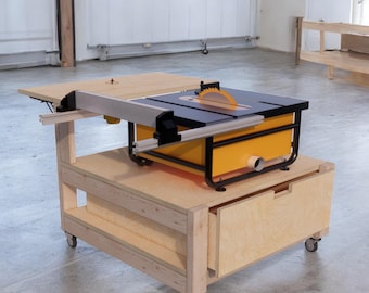 May include: A wooden table saw stand with a drawer and a shelf. The stand is on wheels and has a black and yellow table saw on top.