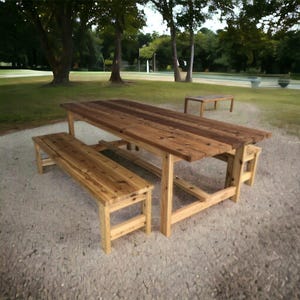 May include: A rustic wooden picnic table with two benches. The table is made of reclaimed wood and has a natural finish. The benches are also made of wood and have a natural finish.