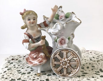 Vintage ceramic figural vase, girl on wheeled cornucopia