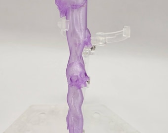 May include: A translucent purple 3D printed object with a long, thin, and slightly curved shape. The object has a series of bumps and ridges along its length.