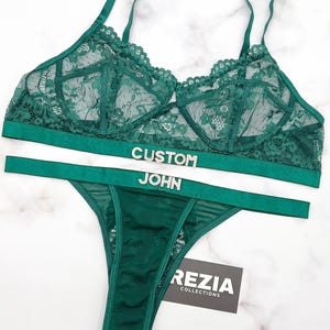 May include: Green lace lingerie set with a white band that says "CUSTOM JOHN".