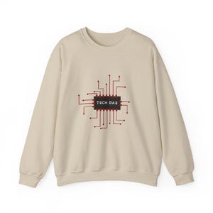 Puede incluir: Sudadera beige con un diseño rojo y negro de placa de circuito y el texto blanco "TECH BAE". La sudadera de manga larga tiene cuello redondo.