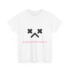 Puede incluir: Camiseta blanca con una cara de dibujos animados negra con X para los ojos y un ceño fruncido. El texto "your password strength offends me" está impreso debajo de la cara.