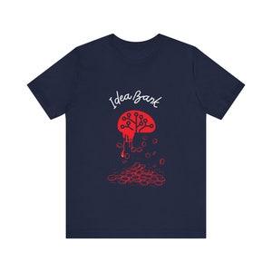 Puede incluir: Camiseta azul marino con un gráfico de cerebro rojo y el texto "Idea Bank". El cerebro gotea líquido rojo, que forma una pila de monedas rojas.