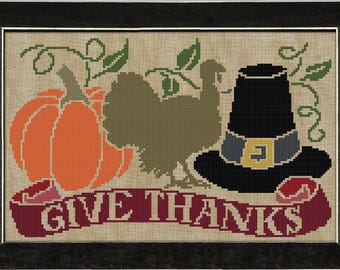 May include: A cross-stitch design featuring a pumpkin, a turkey, and a pilgrim hat with the text "Give Thanks". The design is on a beige background with green vines.