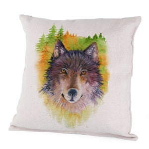 May include: Square throw pillow featuring a watercolor painting of a wolf's face. The wolf has brown and black fur with orange eyes. The background includes green and orange trees, creating a nature-themed design.