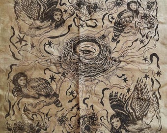 Può includere: Tessuto beige con una dettagliata illustrazione a inchiostro nero. L'opera raffigura un nido centrale con un occhio, circondato da figure alate, stelle ed elementi floreali. Lo stile ricorda un'estetica vintage o gotica.