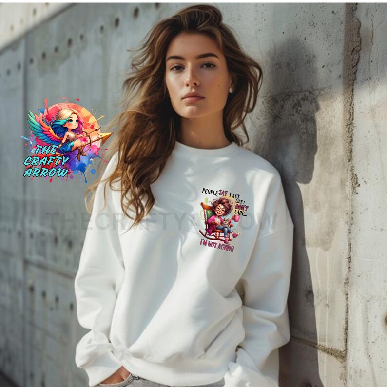 May include: White sweatshirt with a graphic of a woman sitting in a rocking chair with the text "People say I act like I don't care. I'm not acting."