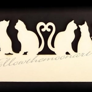 May include: White silhouette of seven cats in a row on a cream-colored background. The cats are in various poses, including sitting, standing, and lying down. The background has the text "followthemoonart" in a cursive font.