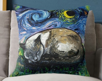 May include: A throw pillow with a painting of a cat sleeping on a blue and white background with stars and a crescent moon. The cat is gray and white and is curled up in a ball.