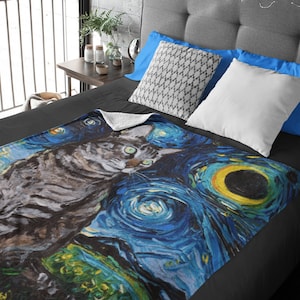 May include: A soft, plush throw blanket featuring a gray tabby cat standing in front of a swirling blue and yellow starry night sky, reminiscent of Vincent van Gogh's famous painting.