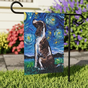 May include: A garden flag featuring a stylized painting of a Springer Spaniel dog in front of a blue and yellow starry night sky. The dog is brown and white and is sitting up looking to the left. The flag is made of fabric and has a sewn-in sleeve for hanging.