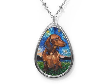 Puede incluir: Collar plateado con un colgante ovalado que presenta un perro salchicha pintado al estilo de "La noche estrellada" de Van Gogh. El perro marrón está sentado en un campo de hierba, con un cielo estrellado de fondo.
