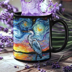 May include: Black coffee mug with a colorful painting of a heron standing in a body of water with a starry night sky in the background.