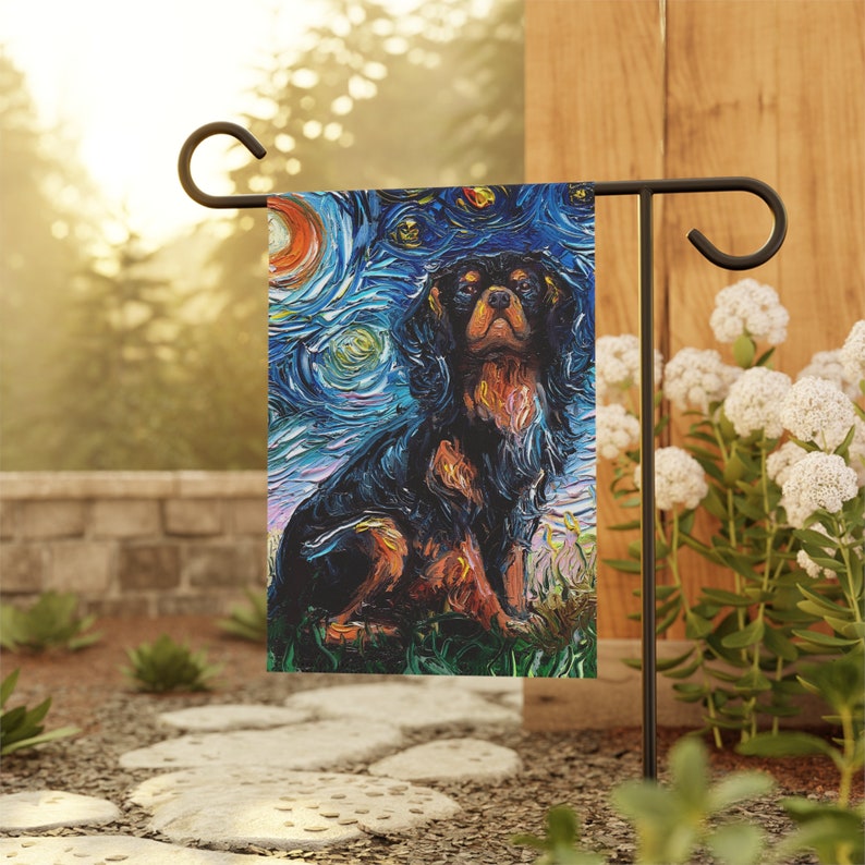 May include: A garden flag featuring a black and brown Cavalier King Charles Spaniel dog painted in a style reminiscent of Vincent van Gogh's "Starry Night". The dog is sitting and looking directly at the viewer.
