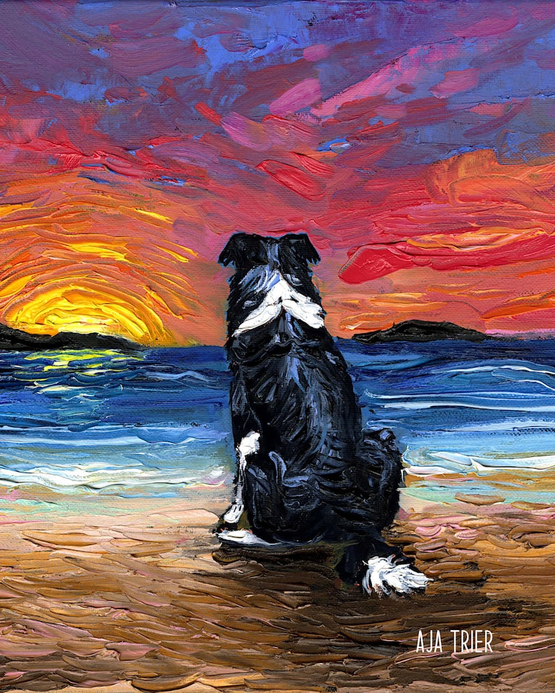 May include: A black and white border collie dog sits on a sandy beach, looking out at a colorful sunset over the ocean. The sky is a mix of pink, orange, and purple, with a bright yellow sun setting in the distance.