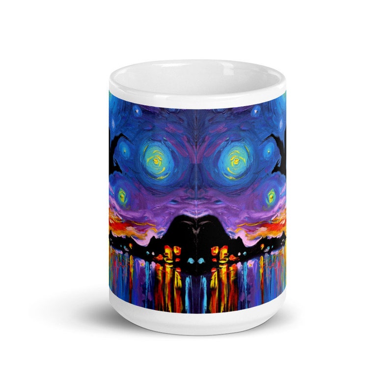 May include: White ceramic mug with a colorful abstract design. The design features a dark silhouette of a city skyline with a purple and blue sky with yellow stars. The bottom of the mug features a reflection of the city lights in the water.